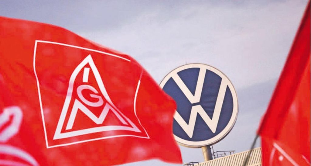 Les drapeaux du syndicat IG Metall devant le logo de Volkswagen
