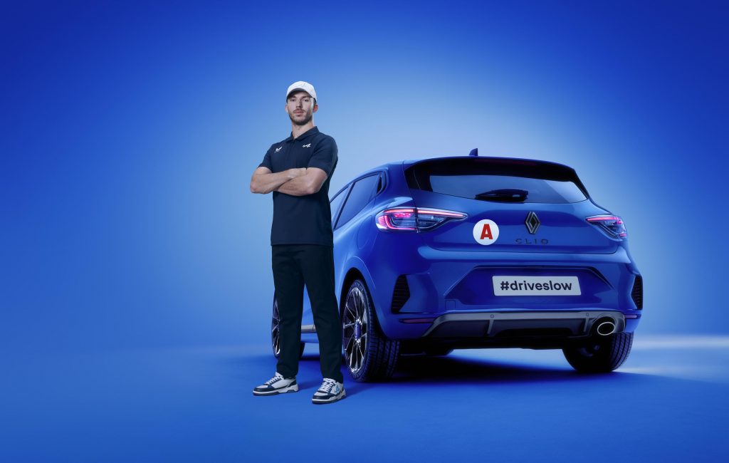 Le pilote Alpine F1, Pierre Gasly à côté d'une Clio avec le slogan #DriveSlow