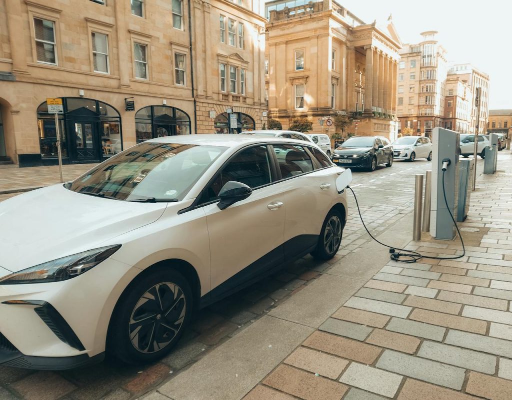 Une électrique en véhicule d’occasion : bonne ou mauvaise idée ? Une voiture électrique en train de recharger dans une rue de Glasgow.